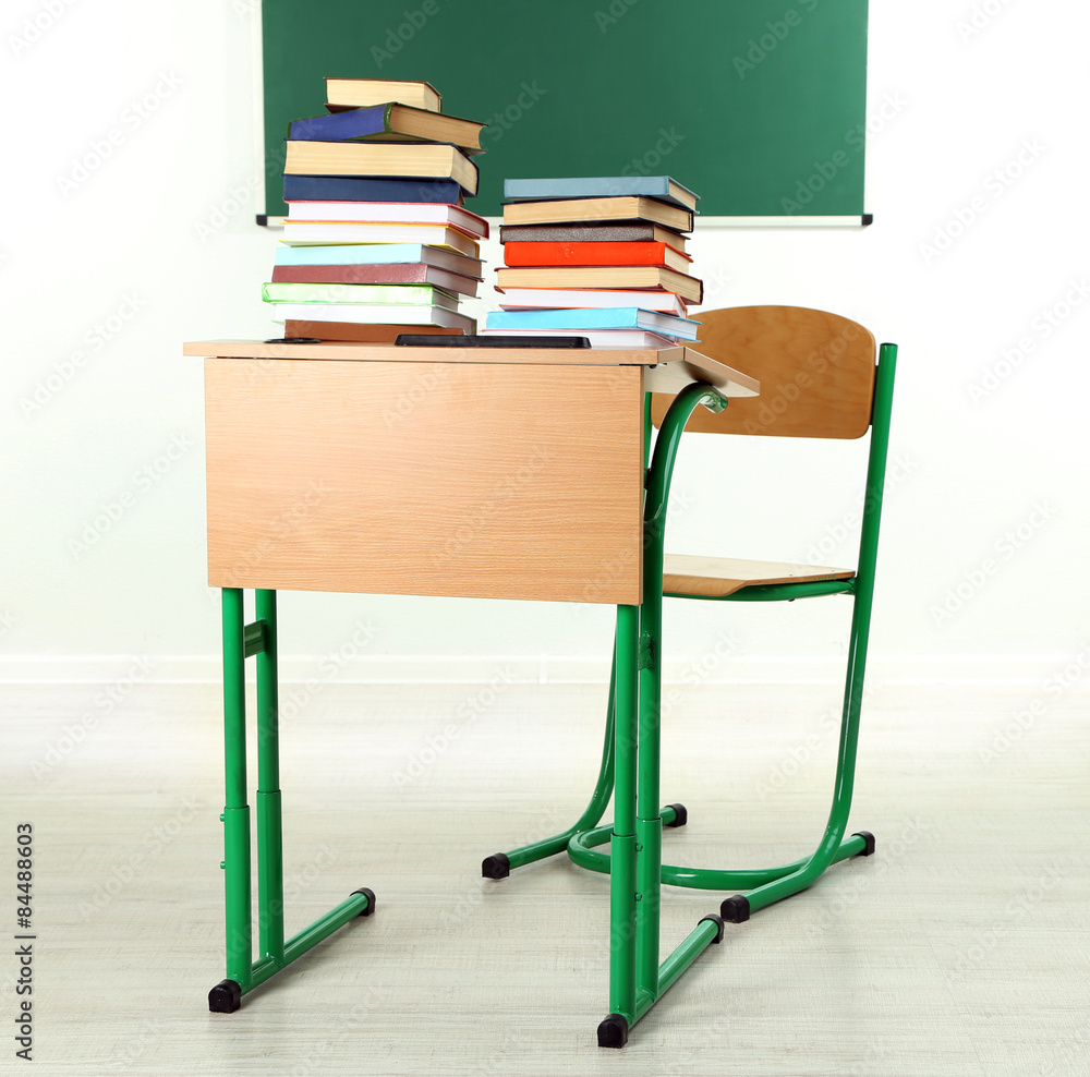 Sticker Wooden desk with books and chair in class on blackboard background