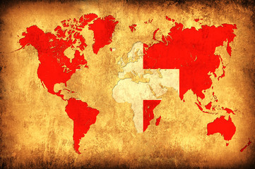 The flag of Switzerland in the outline of the world map