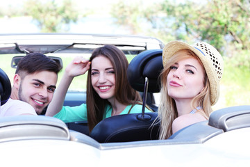 Three friends in cabriolet, outdoors