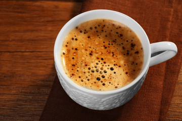 Cup of fresh coffee on wooden table, closeup