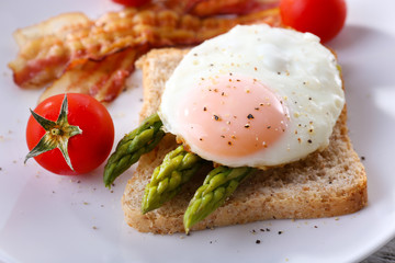 Dish of asparagus and egg in plate on table, closeup