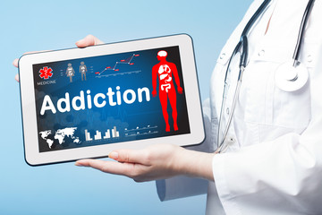 Girl holding Tablet with the diagnosis Addiction on the display.