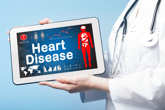 Girl holding Tablet with the diagnosis Heart disease on the disp