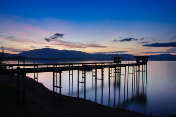 Fototapeta na wymiar old bridge at the lake with sunrise.