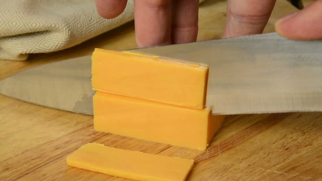 Slicing cheddar cheese closeup
