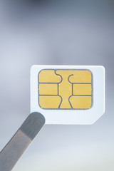 Sim card for smart mobile phone with tweezer, close up