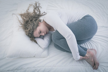 Woman curled up in bed