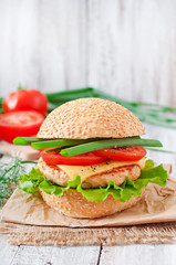 Sandwich with chicken burger, tomatoes, cheese and lettuce