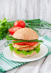 Sandwich with chicken burger, tomatoes, cheese and lettuce