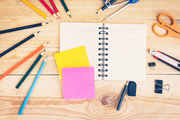 Notebook paper and school or office tools on wood table for back