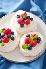 pavlova meringue cake with cream and berry