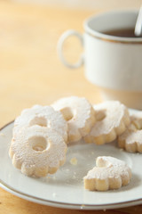 Nibbled italian Canestrelli biscuits near a cup of black tea