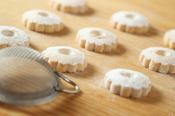 Fototapeta na wymiar Italian canestrelli cookies with a strainer for icing sugar