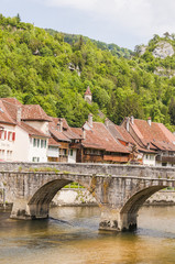 Fototapeta na wymiar Saint-Ursanne, St-Ursane, Altstadt, Stadtmauer, Bogenbrücke, historische Brücke, Doubs, Fluss, Jura, Schweiz