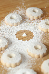 Italian canestrelli biscuits sprinkled with powdered sugar with a missing cookie