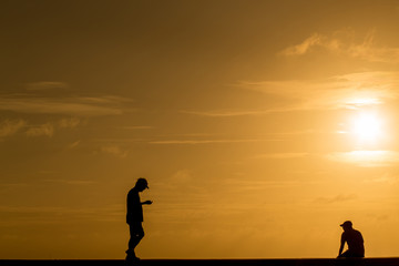 Fototapeta premium Silhouette people walking at sunset