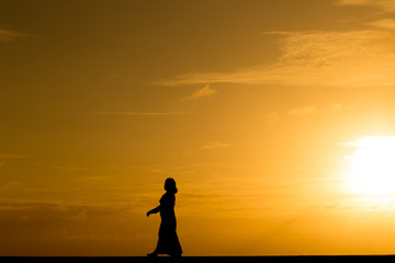 Fototapeta premium Silhouette people walking at sunset