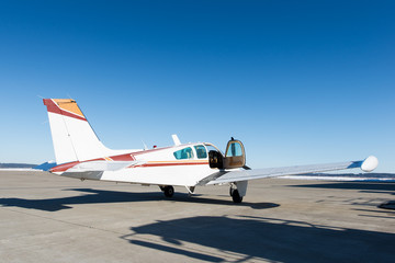 opened door of small propeller-driven aircraft at airstrip