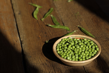 Pea in a ceramic bowl on the wooden background