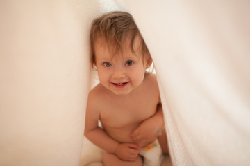 Toddler hiding under blanket after bath