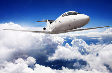 Naklejka na ściany i meble Private jet plane in the blue sky