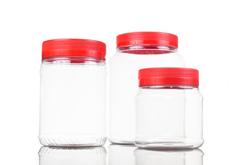 Three translucent plastic PVC jar with red cover isolated in white