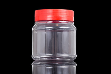 Translucent plastic PVC jar with red cover isolated in black