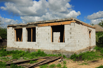 Fototapeta na wymiar House construction site with blue cloudy sky 