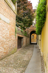 Small ancient street in the old downtown of Ferrara, Italy