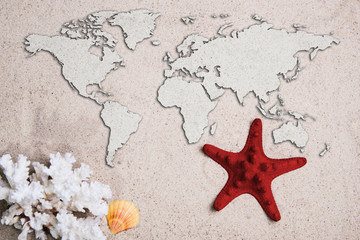 Map of the world. Traveling concept. Starfish with coral on the Beach sand