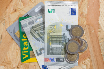 Concept of expensive healthcare with coins,notes and french health card