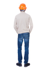 Backview of an engineer in construction helmet stands. Standing
