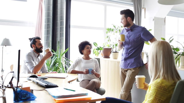 happy creative team drinking coffee in office