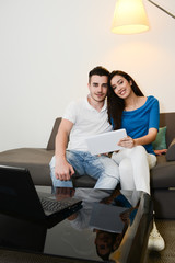 cheerful happy young couple at home playing on internet with computer