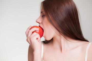 beautiful girl eating red apple