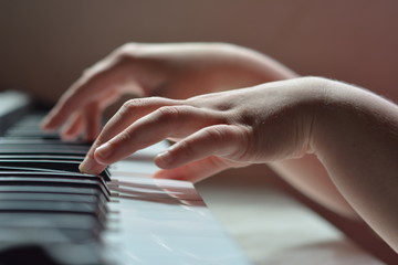 руки на клавиатуре рояля при дневном освещении