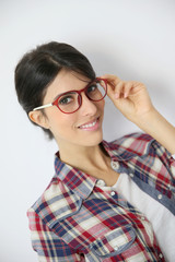 Fototapeta premium Portrait of brunette girl with red eyeglasses on, isolated
