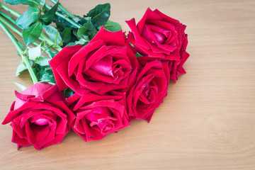 Red roses on wooden vintage table