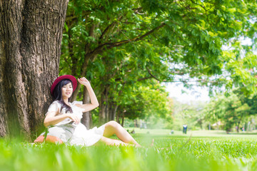 Naklejka na ściany i meble Asian woman sitting in park