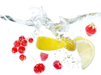Fototapeta na wymiar Fresh fruits and berries splashing in water isolated on white