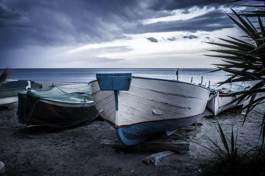 Tipiche barche ligure "gozzi" tirate in secca sulla spiaggia al tramonto