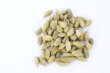Green cardamon pods scattered and isolated on a white background