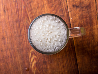 glass of fresh lager beer on wooden table