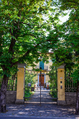 Fototapeta premium Cancello di ferro chiuso, ingresso a villa gialla