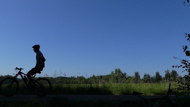 Mountainbiker f&auml;hrt freih&auml;ndig als Silhouette vorbei, in Zeitlupe