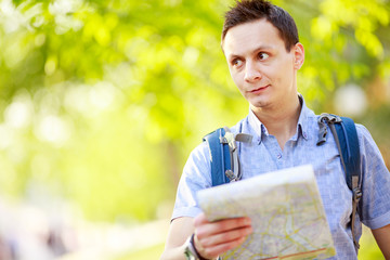 Young man with a map outdoors