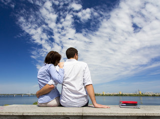 Young couple and cloudy sky