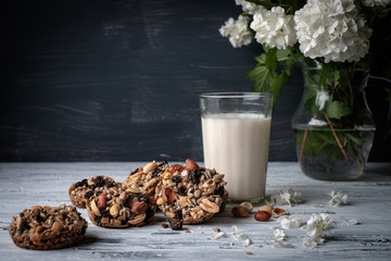 Glass of milk and cookies made of nuts and raisins