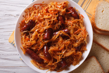 stewed cabbage with sausages close-up horizontal top view
