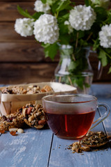 Cup of tea and cookies made of nuts and raisins.
